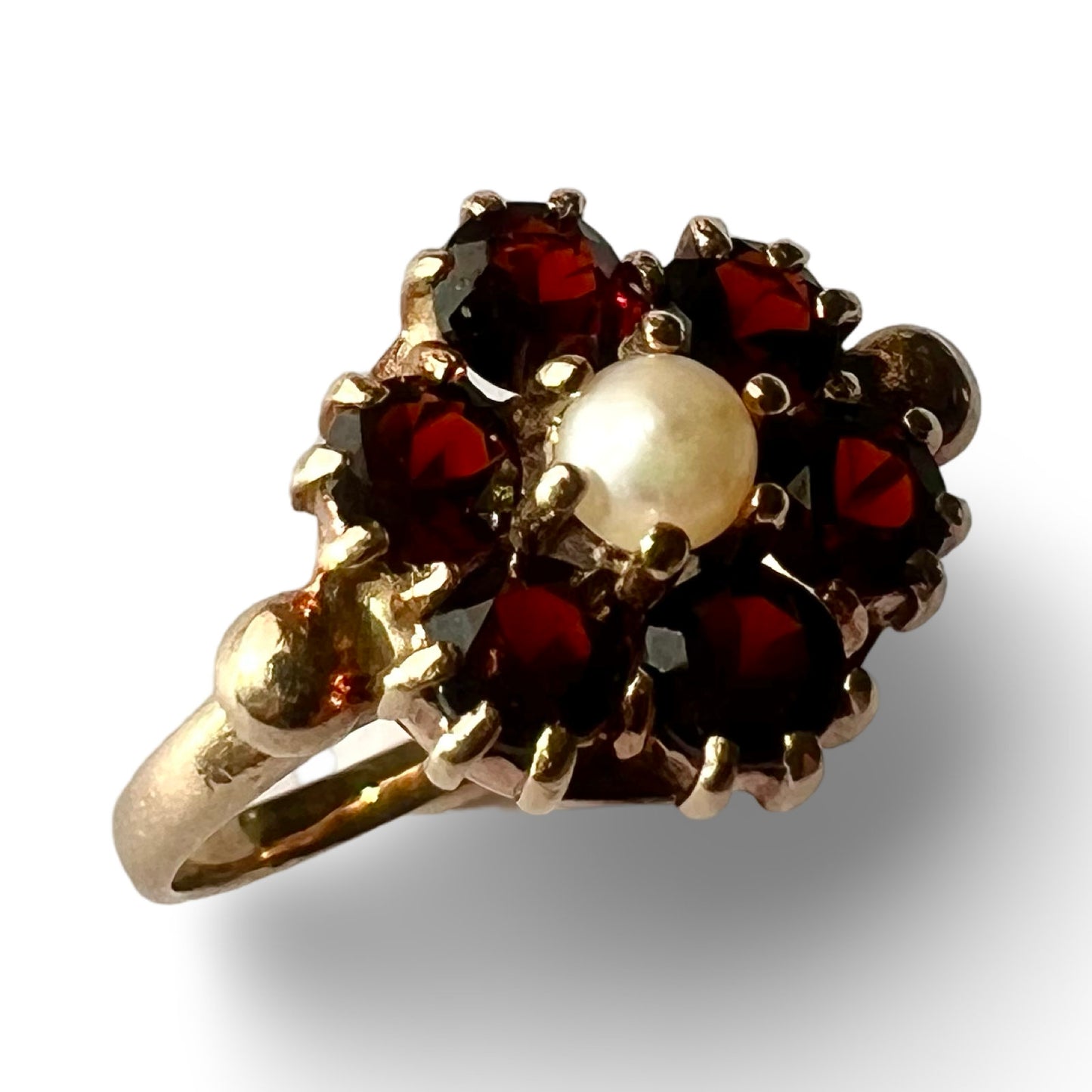 Angled view of vintage 9ct gold pearl and garnet cluster ring showing overall design and gemstone layout